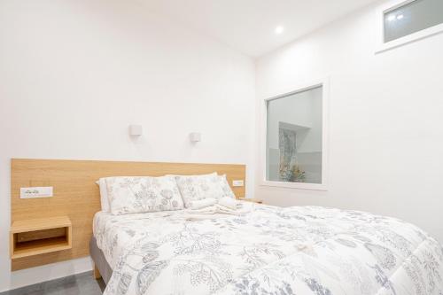 a white bedroom with a bed and a window at Eos - Elegants Apartments & Suites in Siracusa