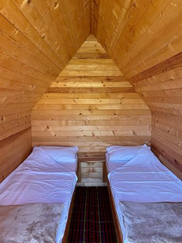 a room with two beds in a wooden cabin at Djedov do 2 in Babljak