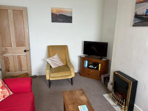 Una sala de estar con un sofá y un televisor. en Bay View, en Swanage