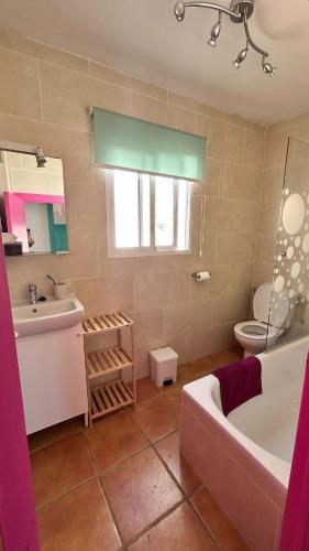 a bathroom with a tub and a sink and a toilet at La Casa de los Colores in Olvera