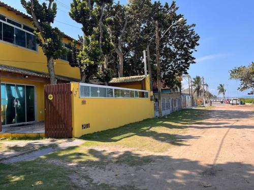 a yellow building on the side of a street at KITNET Beira Mar Prainha Barra - Rio das Ostra in Barra de São João