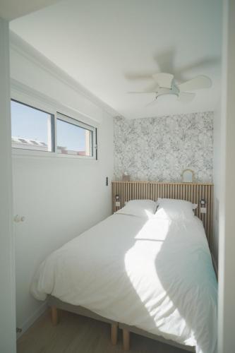 - un lit blanc dans une chambre avec fenêtre dans l'établissement cosy ,lumineux avec parking, à Villeurbanne