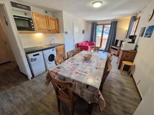 une cuisine et une salle à manger avec une table et des chaises dans l'établissement Les Chalets D'arrondaz - Appartement 6/8 personnes avec vue sur la Vanoise MAE-2912, à Modane