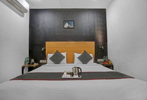 a bedroom with a large bed with a wooden headboard at Townhouse Nangal Raya Pankha Road in New Delhi