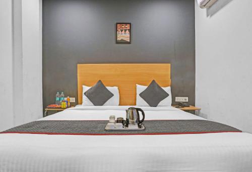 a hotel room with a bed with a tea kettle on it at Townhouse Nangal Raya Pankha Road in New Delhi