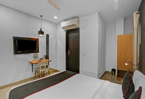 a bedroom with a bed and a desk and a tv at Townhouse Nangal Raya Pankha Road in New Delhi