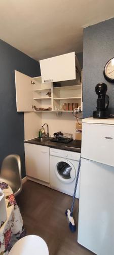 une petite cuisine avec un réfrigérateur et un évier dans l'établissement F1 hyper centre, à Clermont-Ferrand
