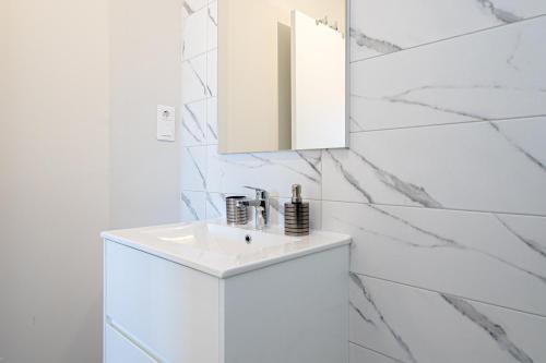 ein weißes Badezimmer mit Waschbecken und Spiegel in der Unterkunft Casa Clara in Villacosta