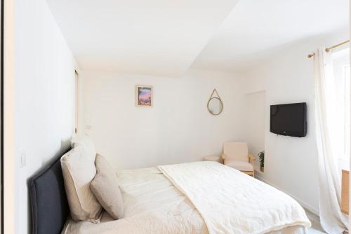 ムージャンにあるCozy modern T2 - Old Village Mouginsのベッドとテレビのある白い寝室
