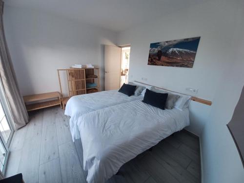 a bedroom with two beds with white sheets at Finca de Luna in La Orotava