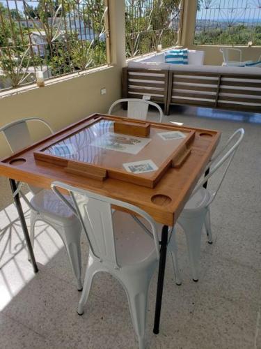 a wooden table with white chairs around it at Casa Campo y mis Memorias-2ND LEVEL-with pool in Hormigueros