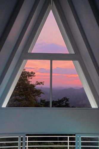 a window in a house with a view of the sunset at Casa Clara Monteverde in Puntarenas
