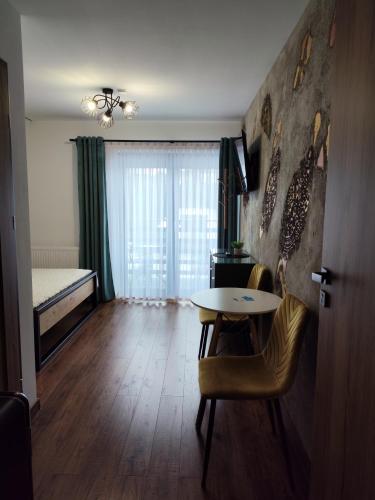 a living room with a table and a bed at Noclegi SKORUSINKA in Witów
