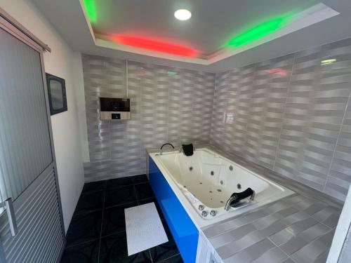 a bath tub in a bathroom with green lights at Hotel Centro vacacional El Cielo in Rivera