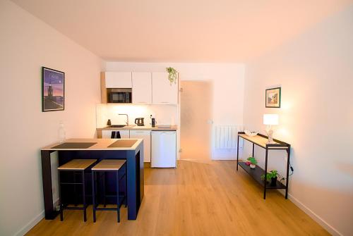 une cuisine avec une table et des chaises dans une pièce dans l'établissement Le Belvédère, idéalement situé centre, balcon & port, intendance Luxury Host, à Barneville-Carteret