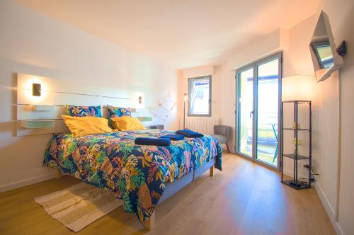 une chambre avec un lit et une grande fenêtre dans l'établissement Le Belvédère, idéalement situé centre, balcon & port, intendance Luxury Host, à Barneville-Carteret