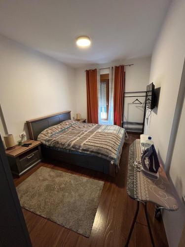 a bedroom with a bed and a desk and a television at Urban Apartment Master Quart in Podgorica