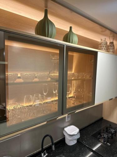 a kitchen cabinet filled with glasses and dishes at Melhor cidade do Brasil! Melhor apto. do Brasil! in Sorocaba