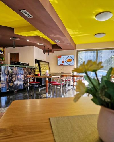 a restaurant with tables and chairs and a yellow ceiling at Hotel Brkić Sarajevo Airport - Free Parking in Sarajevo