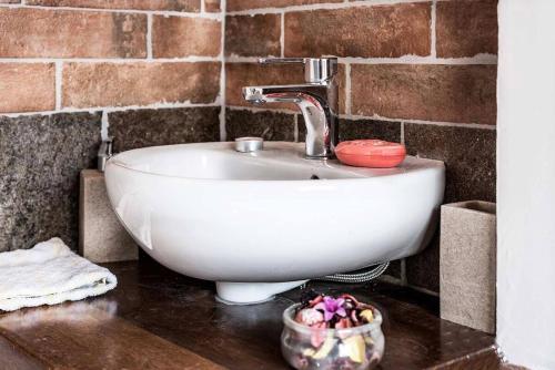 a white sink in a bathroom with a brick wall at Villa Il Rustichino, country Villa with Pool in Soianella