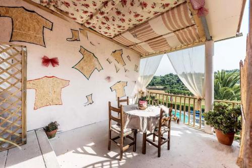 a table and chairs on a balcony with stars painted on the wall at Villa Il Rustichino, country Villa with Pool in Soianella