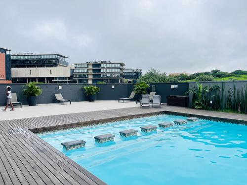 a swimming pool on the roof of a building at Cozy Mellenial Umhlanga studio in Durban