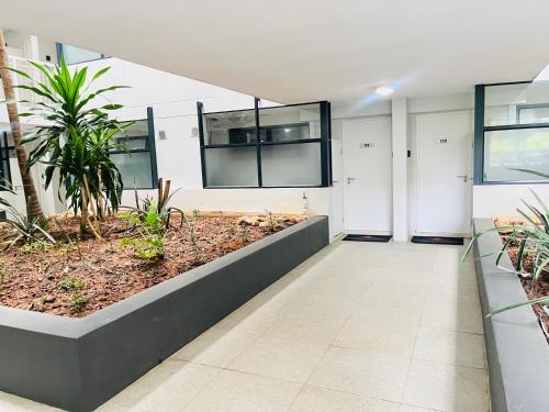 an empty hallway in a building with plants at Cozy Mellenial Umhlanga studio in Durban