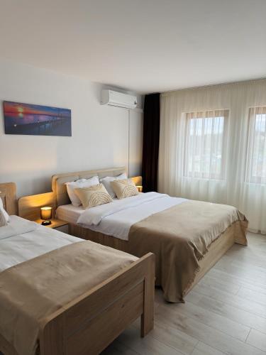 a hotel room with two beds and a window at Pensiune Restaurant Indus in Ocna Sibiului