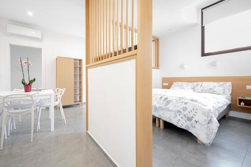 a bedroom with a bed and a table and a table and chair at Eos - Elegants Apartments & Suites in Siracusa