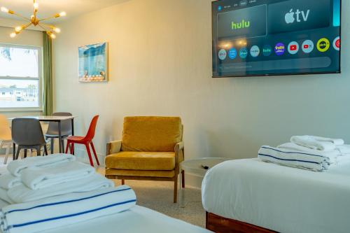 a room with two beds and a chair and a table at Tropical Breeze in Clearwater Beach