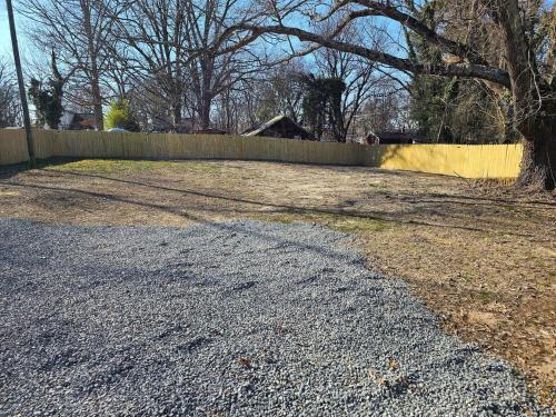 a road in a yard with a fence and a tree at Oasis within a short walk to uptown in High Point