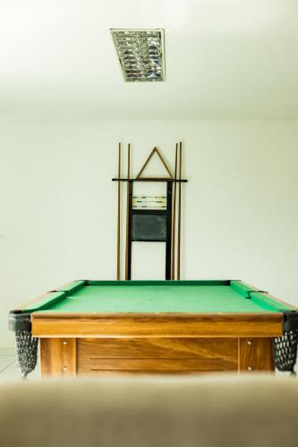 a pool table with a green top and a mirror at Estação do Sol Praia Hotel in Porto De Galinhas