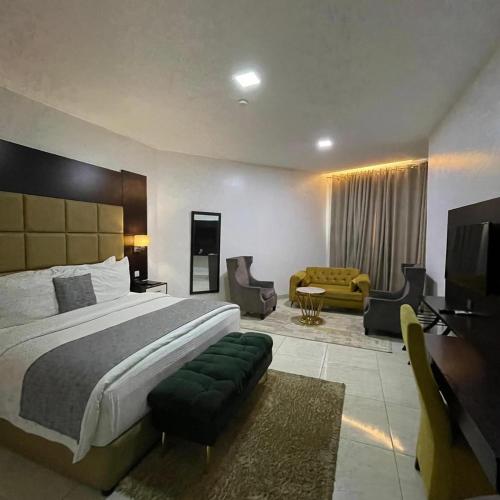 ニューデリーにあるHotel Olive Suites Delhi International Airportの大きなベッドとリビングルームのある寝室