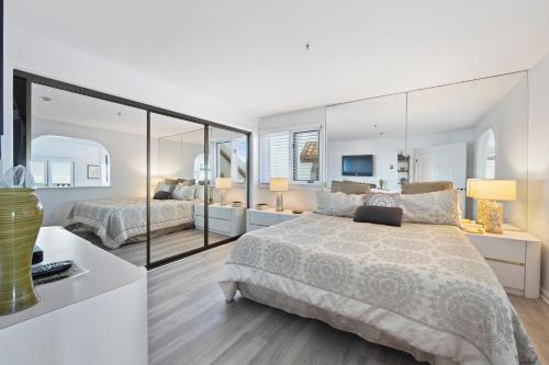 a bedroom with two beds and a large mirror at H242 - Hamilton Cove Villa 2-42 in Avalon