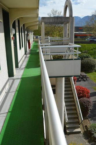 a hallway of a building with a green floor and stairs at Premiere Classe Chambery in Chambéry