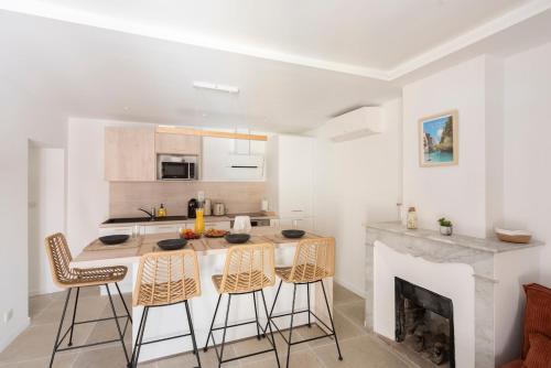une cuisine avec une table et des chaises ainsi qu'une cheminée dans l'établissement Cozy modern T3 - Old Village Mougins, à Mougins