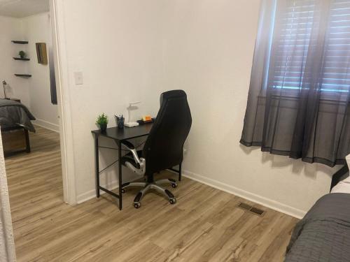a desk in a bedroom with a chair and a bed at Serenity on over an acre easy access to 311 and HPU in High Point