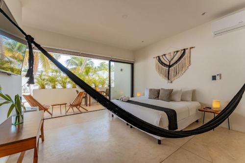a bedroom with a bed and a hammock at Loft con alberca en Telchac in Telchac Puerto