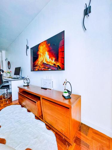a living room with a desk with a fire under a tv at Urban Vibes Getaways - Premium Westlands Nairobi Apartment with Luxury Amenities in Nairobi