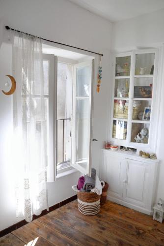 Cette chambre dispose d'une fenêtre et d'un panier sur le parquet. dans l'établissement Charmante maison de village en plein Grignan, à Grignan