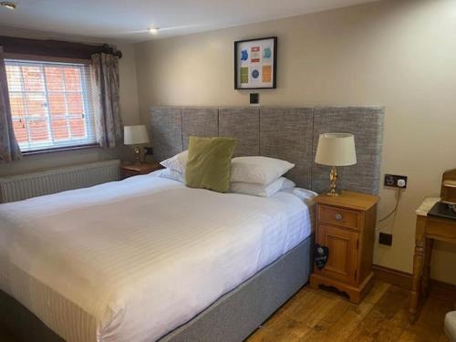 a bedroom with a large white bed and a window at Sebastians in Oswestry