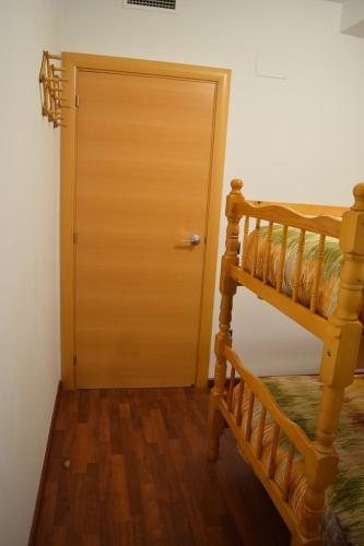 a wooden door in a room with a ladder at Benissanet Tarragona Apartment Cal Sanet in Benissanet
