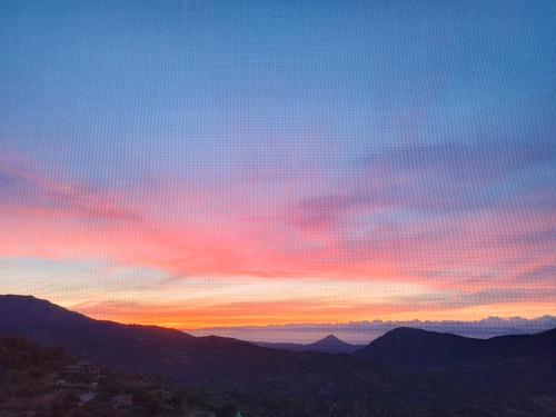 a sunset with a view of the mountains at Appartamenti La Collina in Jerzu