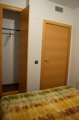 a bedroom with a bed and a closet and a door at Benissanet Tarragona Apartment Cal Sanet in Benissanet