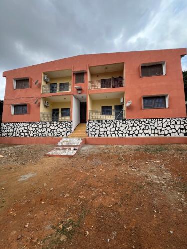 a orange building with a yard in front of it at Mon havre in Yaoundé