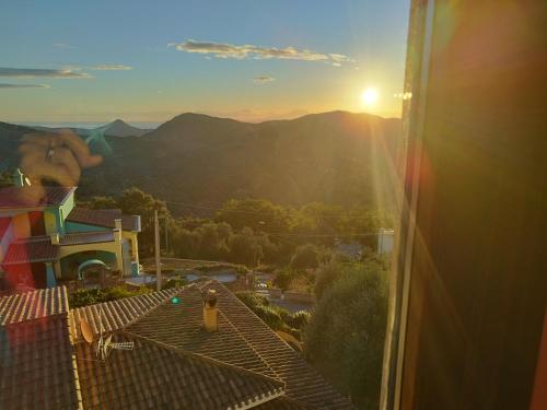 a view of the sunset from a balcony of a house at Appartamenti La Collina in Jerzu