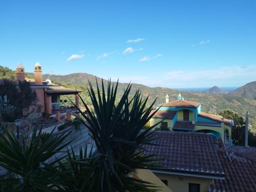 a view of a house with mountains in the background at Appartamenti La Collina in Jerzu