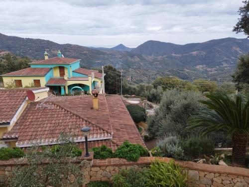 a house on top of a roof with mountains in the background at Appartamenti La Collina in Jerzu