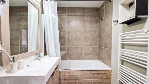 une salle de bain avec une baignoire, un lavabo et une douche dans l'établissement Résidence Le Panoramic - Appartement chaleureux · Départ et retour skis aux pieds · Piscine · Spa MAE-6941, à Magland