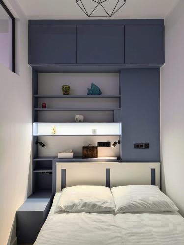 a bedroom with a bed with a blue headboard at Century Apartment in Wrocław